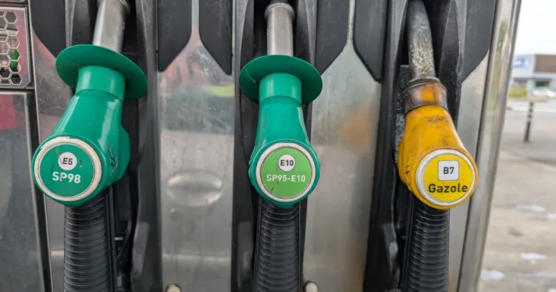 Trois pistolets de pompe à essence, SP98, SP95-E10 et gazole, avec leurs codes couleur normalisés