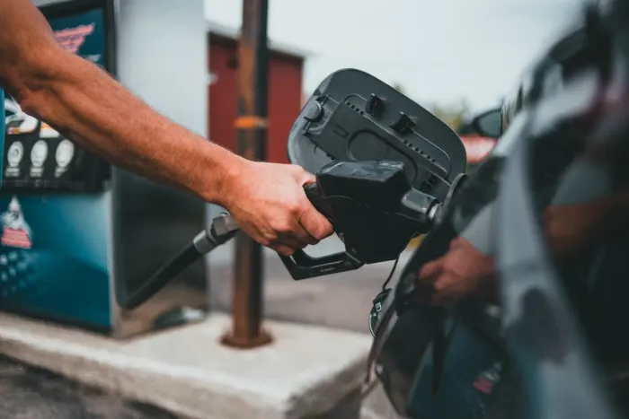 Main tenant un pistolet de carburant pour faire le plein d'une voiture