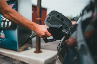 Main tenant un pistolet de carburant pour faire le plein d'une voiture