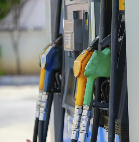 Gros plan sur plusieurs pistolets de distributeurs de carburant côte à côte à une pompe