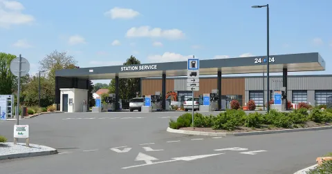 Station-service de grande surface avec pompes en libre-service et voitures en train de faire le plein