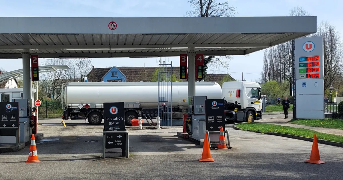 Station-service Super U avec son totem de prix et un camion-citerne en cours de livraison