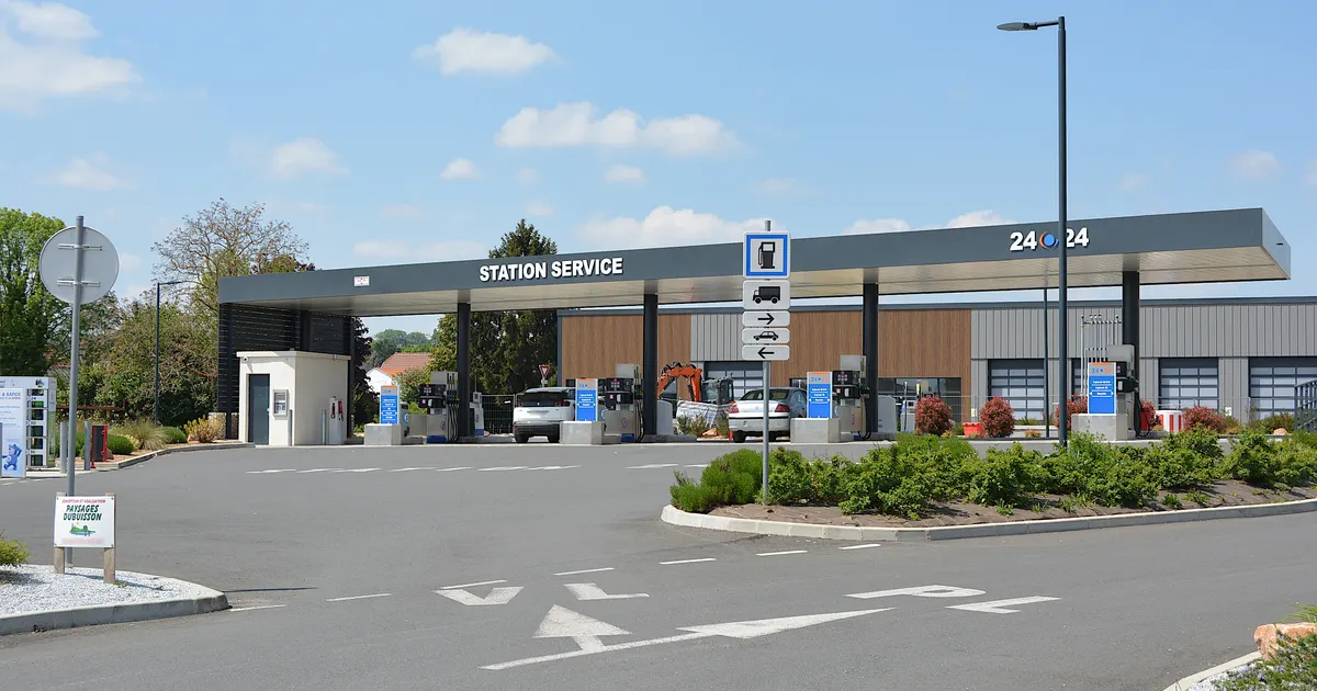 Station-service de grande surface avec pompes en libre-service et voitures en train de faire le plein